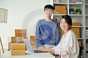 A successful young Asian couple, small online business owners are in their home office