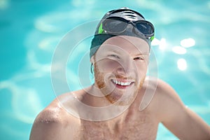 Successful young bearded man in swimming cap