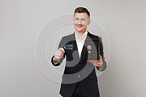 Successful young business man in classic suit hold credit bank card, metal bank safe for money accumulation isolated on