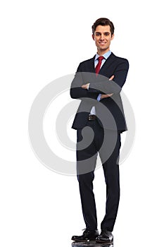 Successful young business man standing with hands crossed