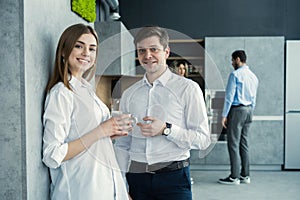 Successful young business people sharing ideas and smiling during the coffee break.