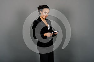 Successful young business woman with hands folded smiling over grey background