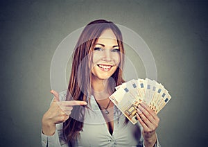 Successful young business woman holding money euro bills in hand