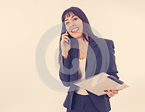 Successful young business woman talking on phone holding a folder. Isolated on white background