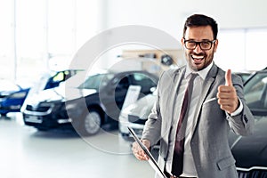 Successful businessman in a car dealership - sale of vehicles to customers