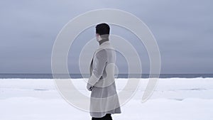 Successful young businessman standing in field covered in snow