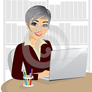 Successful young businesswoman working typing on her laptop at office