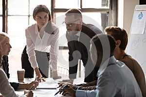 Successful young female team leader listening to coworkers ideas.