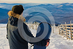 Successful young man snowboarding in the mountains Sheregesh. Snowboarder resting on mountain top. Caucasian snowboarder on a