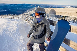 Successful young man snowboarding in the mountains Sheregesh. Snowboarder resting on mountain top. Caucasian snowboarder on a