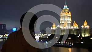 Successful young man standing at balcony city skyline Moscow looking at view of the city at night with beautiful bokeh