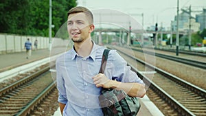A successful young man walks along the train station perron. Arrival on a business trip, travel