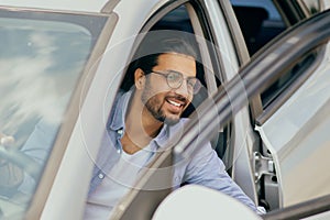 Successful young middle-eastern man going out the car