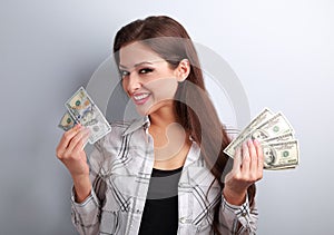 Successful young pretty woman holding dollars in two hands with