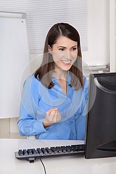 Successful young smiling business woman sitting in her office.