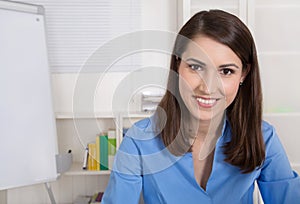 Successful young smiling business woman sitting in her office.