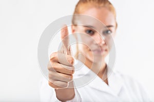 Successful young woman giving a thumbs up gesture