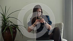 successful Young Woman in glasses Chatting On Phone Living Room. Writing Searching Using IT. Happy smiling Buisenes Lady