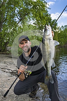 Successful zander fishing. Happy fisherman with walleye fish