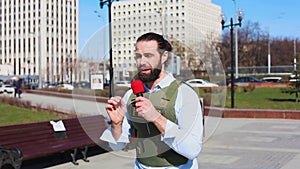 Successfull news reporter with microphone in hand talking live on the street