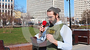 Successfull news reporter with microphone in hand talking live on the street