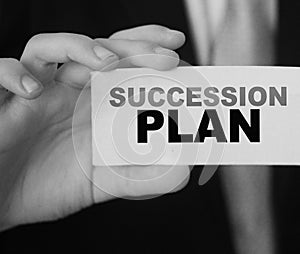 Succession Plan words on a card in hand of businessman. Business profit and success concept