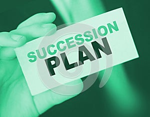 Succession Plan words on a card in hand of businessman. Business profit and success concept