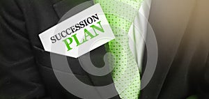 Succession Plan words on a card in upper pocket of businessman wearing green tie. Business profit and success concept