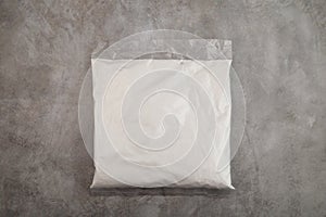 Succinic acid powder in plastic bag on grey background. Butanedioic acid or spirit of amber. White powder,
