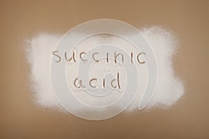 Succinic acid powder scattered on brown surface