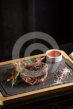 Succulent grilled beef steak with red wine, seasonings, fresh rosemary and grilled vegetables on cutting board