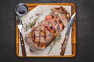 Succulent grilled large striploin steak garnished with herbs and salt