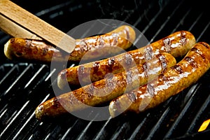 Succulent juicy sausages grilling on a BBQ photo