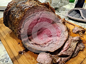 Succulent Medium-Rare Prime Rib Roast on Wooden Board in Home Kitchen