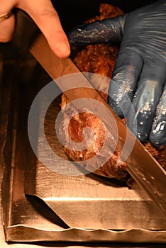 Succulent roast leg of lamb with chef hand and carving knife