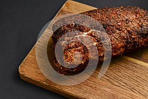 Succulent thick juicy grilled fillet steak served on an old wooden board over black background