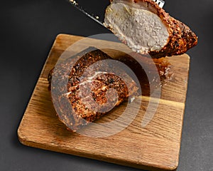 Succulent thick juicy grilled fillet steak served on an old wooden board over black background