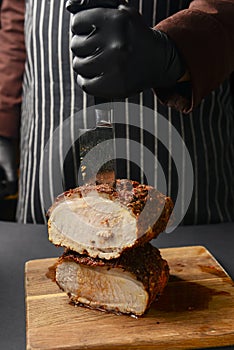 Succulent thick juicy grilled fillet steak served on an old wooden board over black background