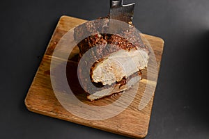 Succulent thick juicy grilled fillet steak served on an old wooden board over black background