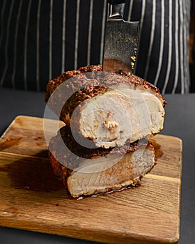 Succulent thick juicy grilled fillet steak served on an old wooden board over black background