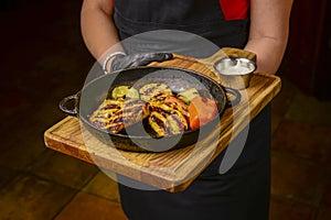 Succulent thick juicy portions of grilled fillet steak served with roast vegetables on an old wooden board