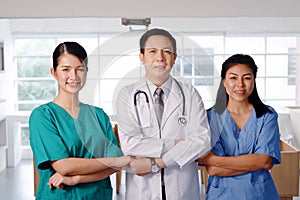 Sucessfull of professional Asian chief physician man and surgeon doctor women wears blue and green surgical gown together. Smiling