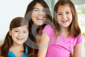 Such beautiful smiles. Portrait of a pretty young mother spending time with her two cute daughters.