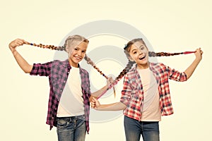 Such a long hair. Happy little girls wear plaited hair. Cute small childred hold hair braids. Luxurious hair extensions