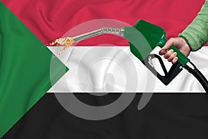 SUDAN flag Close-up shot on waving background texture with Fuel pump nozzle in hand. The concept of design solutions. 3d rendering