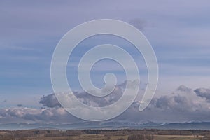 The Sudetes seen from a distance with the peaks partially covered with a layer of dense clouds.