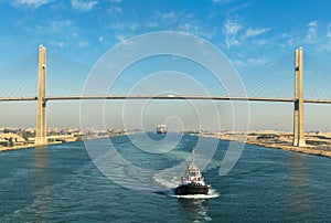 Suez Canal, Egypt, 2017: Ship`s convoy passing through Suez Canal, in the background - the Suez Canal Bridge