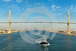 Suez Canal, Egypt, 2017: Ship`s convoy passing through Suez Canal, in the background - the Suez Canal Bridge photo