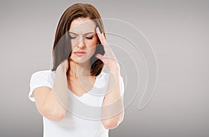 Suffering brunette woman on grey background, headaches