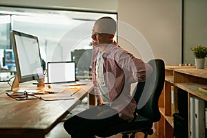 Suffering from the consequences of poor posture. Cropped shot of a young designer experiencing back pain while working